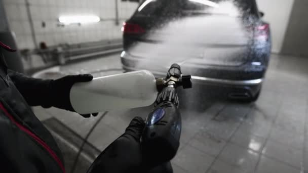 Uomo che copre un'auto con schiuma usando la rondella ad alta pressione. Processo di lavaggio auto. Vista in prima persona. — Video Stock