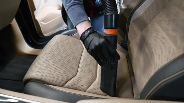 Man stofzuigen een auto cabine met behulp van stofzuiger op een voorstoel in de auto. — Stockvideo