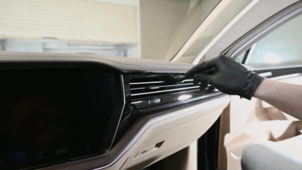 Man clean the duct deflector inside the car from dust using a brush. Deep dry cleaning of the car interior on a automotive detailing center. — Stock Video