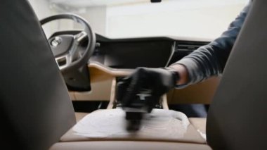 Araba temizleme işçisi pahalı bir arabayı fırça ve köpükle yıkıyor..
