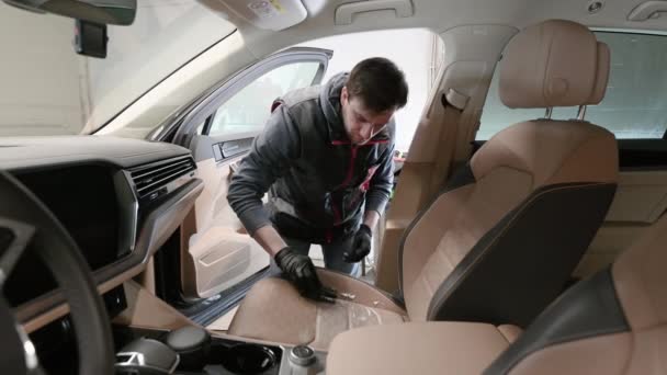 Man reinigen auto interieur met behulp van schuim chemische en detaillering borstel. — Stockvideo