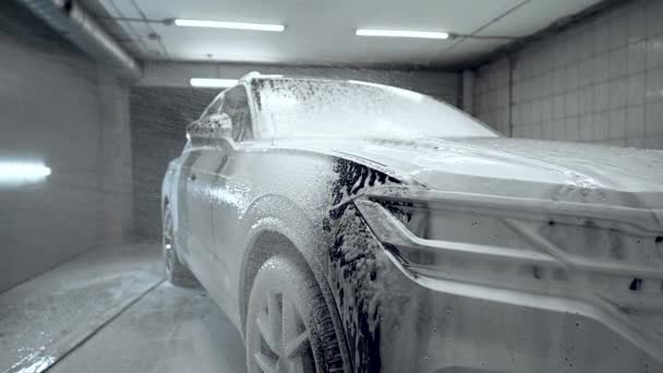Близько до процесу миття автомобілів. Піноутворювач покриває машину, очищає її від бруду. Повільний рух, докладний . — стокове відео