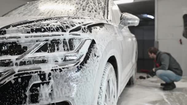 Servicio de coches: El trabajador lava las llantas del coche con un cepillo suave con champú — Vídeos de Stock