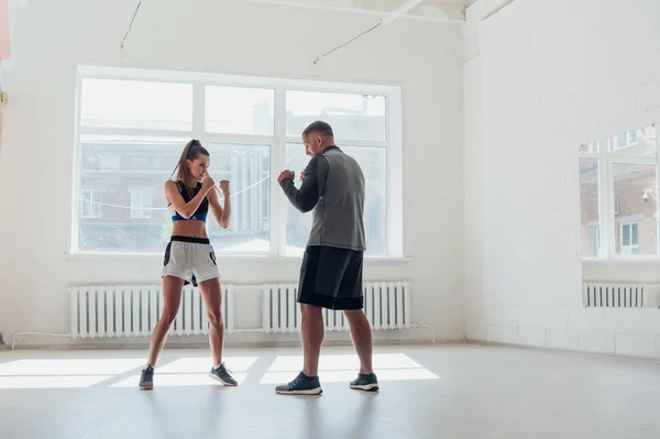 Donna che allena la boxe con personal trainer. Istruttore insegnare boxer femminile pratica di combattimento insieme — Foto Stock