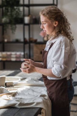 Kadın çömlekçi kilden vazo yontuyor. Çömlek atölyesi. Hobi