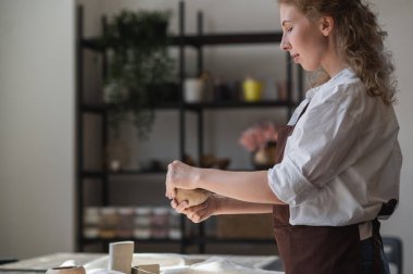 Genç bir çömlekçi kadın kendi iş yerinde esrar yapıyor. Geniş bir stüdyoda duruyor. Elleriyle geleceğin ürününün şeklini oluşturuyor..