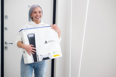 Kadın, kardeşine bir sonraki nesil Sony Playstation 5 konsolu, online alışveriş hediyesi ve siber spor için modern video oyunu aletiyle sürpriz yapıyor. Moskova - 28 Kasım 2020.