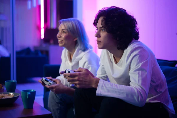 Cheerful boyfriend and girlfriend playing video games to win. Happy couple  using controller to play online game and winning gameplay on console.  People holding joystick to have fun Stock Photo - Alamy