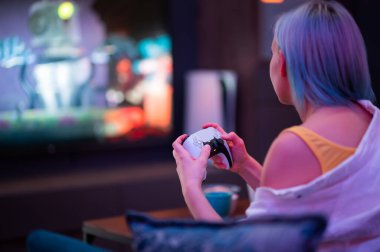 Evde PlayStation 5 oyun konsolu oynayan bir kız. Moskova - 28 Kasım 2020.