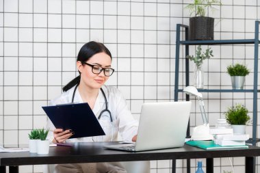Ofisteki maske takan doktor kameraya bakıyor.