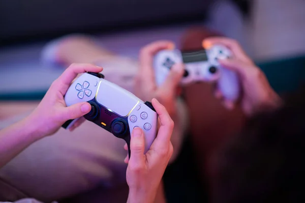 Ulike generasjoner av PlayStation-konsollkontrollere: PS5 DualSense-kontrollere og PS4 DualShock-kontrollere i hendene på spillere. Moskva - 28. november 2020. – stockfoto