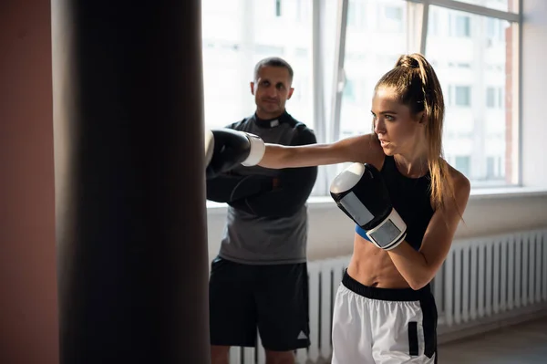 스포츠 트레이너 랑싸우는 아름다운 여성 권투 가방이요. 개인 코치로 박스 펀치 운동을 하는 소녀 권투 선수. — 스톡 사진