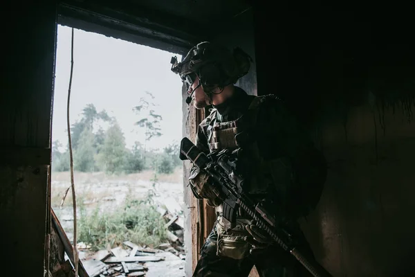 Katonai férfi rohampuskával az épület belsejében, harcra kész. — Stock Fotó
