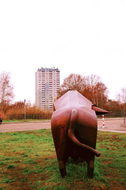 Arka planda boğa heykeli kuyruğu ve arka planda yalnız gökdelen olan kalçaları var.