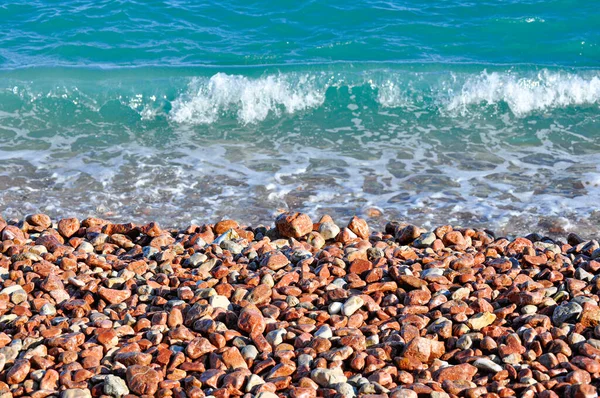 Sea stones, pebbles, sea foam, pebbles on the seashore, water splashes on stones, background with wet stones, sea pebbles on the beach, sea wave on pebbles