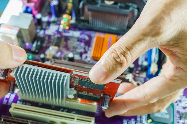 Technician's hands fixing mainboard