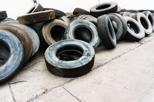 Tires heap on cement ground near wall, used car tires — Stock Image Tires heap on cement ground near wall, used car tires Stock Picture