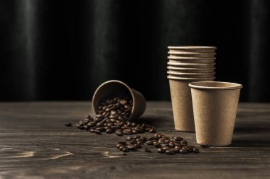 Kahve fincanları ve kahve çekirdekleri ahşap bir masada fotokopi alanı ile serpiştirilmiş. Kahve dükkanlarının reklam geçmişi kavramı.