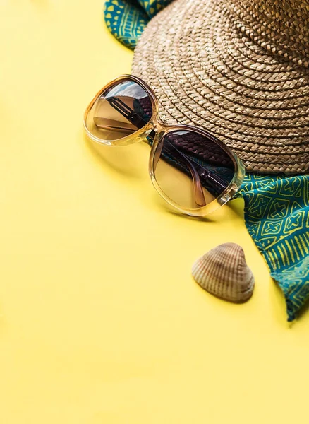 Plaj aksesuarlarıyla dolu parlak bir yaz geçmişi. Plaj terlikleri, güneş gözlükleri, hasır şapka ve deniz kabukları. Kopyalama alanı olan düz