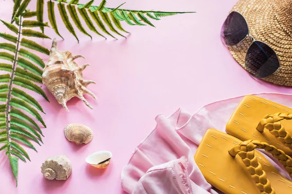 Plaj aksesuarlarıyla dolu parlak bir yaz geçmişi. Plaj terlikleri, güneş gözlükleri, hasır şapka ve deniz kabukları. Kopyalama alanı olan düz.