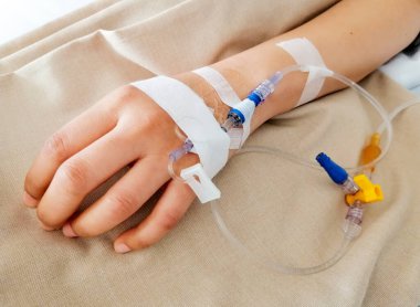 Hasta, elinde salin solüsyonuyla hastanedeki yatakta uyuyor..