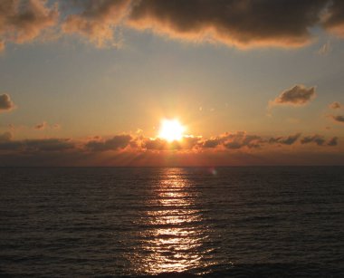 Denizde şafak, yıldız şeklinde güneş.  