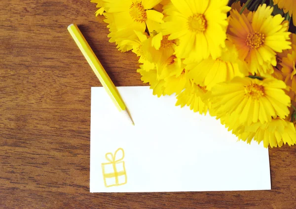 Flores amarelas e cartão de congratulações — Fotografia de Stock