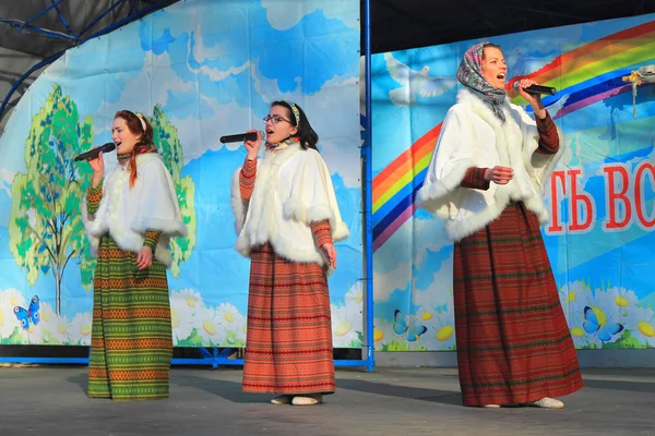 "Imperial Maslenitsa "- três mulheres em ternos nacionais cantam em uma cena — Fotografia de Stock