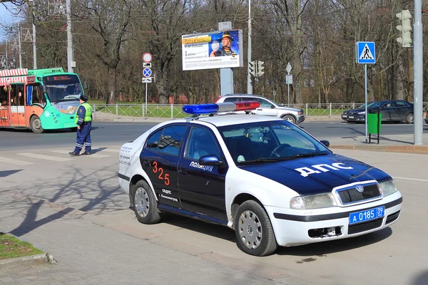 Сотрудник ГИБДД у служебного автомобиля на городской улице — стоковое фото