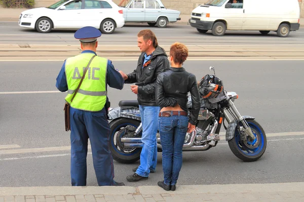 L'officier DPS vérifie les documents d'un motard — Photo