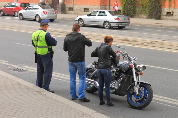 Funzionario DPS controlla i documenti di un motociclista — Foto Stock