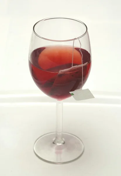Thee en theezakje in glas wijn Rechtenvrije Stockfoto's