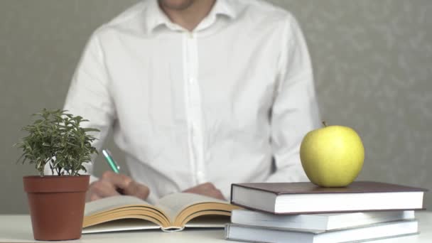 Young Man Studying Stack Books Apple Symbol Knowledge Education Doing — Stock Video