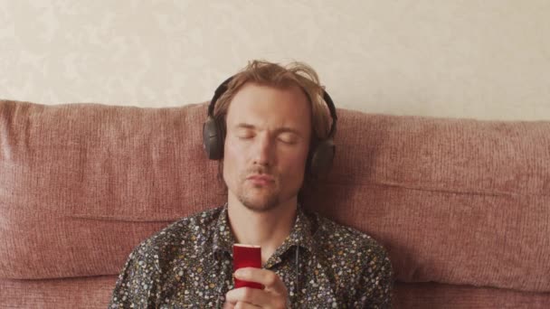 Jovem Thoughtfully Navegando Mp3 Player Ouvindo Música Sofá Leisure Lifestyle — Vídeo de Stock