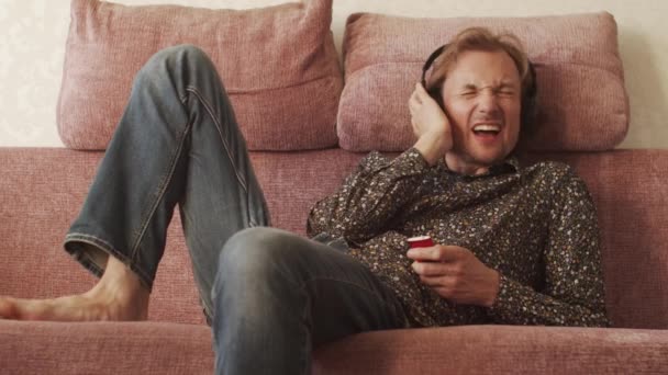 Jeune Homme Heureux Écoutant Musique Sur Canapé — Video