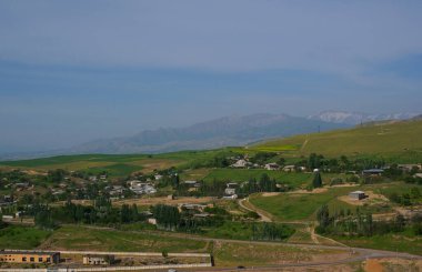                   Houses on the top of the hill, mountain in the background             