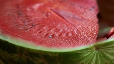 Bir adam büyük bir karpuz kesiyor.