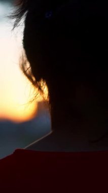 Güneş batarken kız yavaşça yürür.