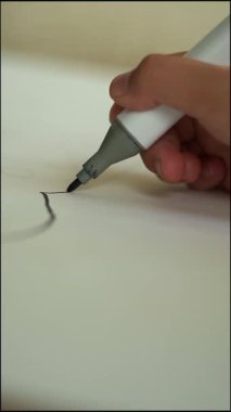 Bir kız odasında oturur ve resim çizer..