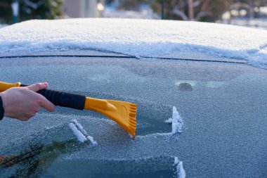 Arabanın ön camını buzdan temizliyorum. Boşluğu kopyala.