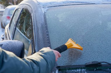 Arabanın ön camını buzdan temizliyorum. Boşluğu kopyala.