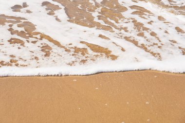 Akdeniz 'in kumlu sahilinde köpüklü dalgalar ufkun ötesine gidiyor. Boşluğu kopyala.