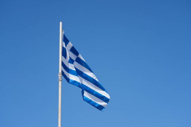 Arka planda mavi ve berrak bir gökyüzü olan Yunanistan bayrağı. Boşluğu kopyala.