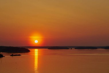 Finlandiya, Naantali 'de altın gün batımı. Güneşin suyun üzerindeki yansıması. Boşluğu kopyala.