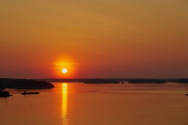                 Finlandiya, Naantali 'de altın gün batımı. Güneşin suyun üzerindeki yansıması. Boşluğu kopyala.              