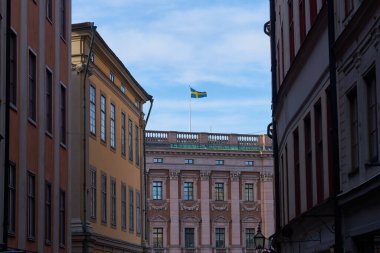 Mavi gökyüzüne karşı evin çatısında İsveç bayrağı. Boşluğu kopyala.