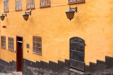 Stockholm 'deki eski bir ortaçağ binasının pencereleri, fenerleri ve demir kapısı. Boşluğu kopyala.