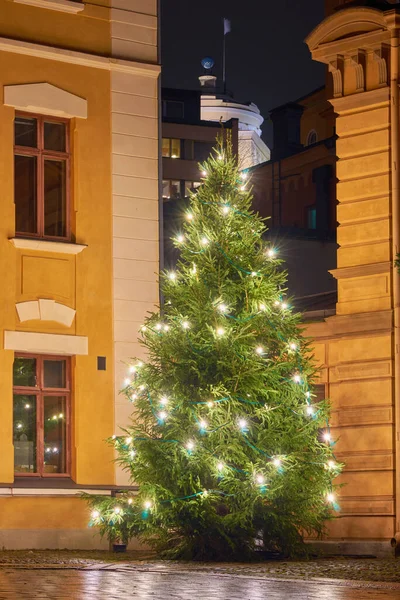 Christmas tree on the street among the old houses. Holidays concept.