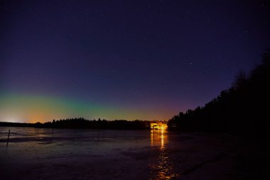Littoinen, Finlandiya 'daki donmuş gölün üzerindeki kuzey ışıkları.