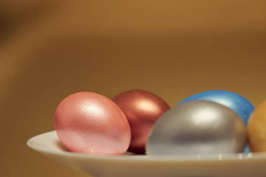 Altın kaplama beyaz bir tabakta boyanmış yumurtalar..